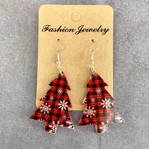Detailed close-up shot of red and black plaid Christmas tree acrylic earrings on card.