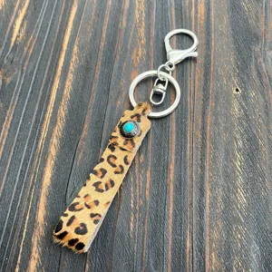 Close-up detail of the leopard print hair-on-hide keychain strap and turquoise button.