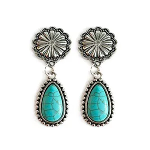 Detailed view of vintage Western turquoise drop earrings with silver sunburst top and beaded trim.