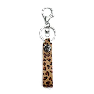 Detailed view of the leopard print calf hair keychain with metal hardware and boho flower charm.