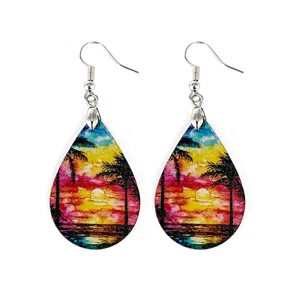 Close-up of tropical sunset wooden teardrop earrings with colorful palm tree art and hooks.