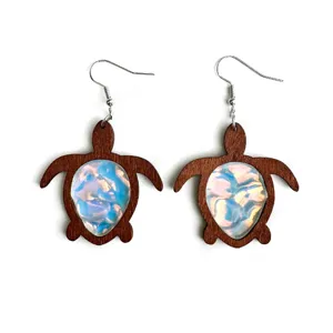 Detailed close-up of wooden sea turtle earrings with iridescent ocean ripple resin insert.