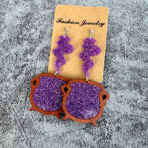 Halloween witch cauldron dangle earrings with purple glitter resin and wood frame design.