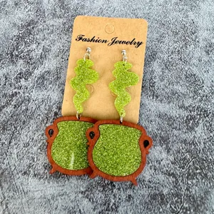 Halloween witch cauldron earrings with green glitter details, long drop festive jewelry design.