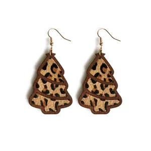 Detailed view of wooden Christmas tree earrings with leopard print calf hair inlay and hooks.