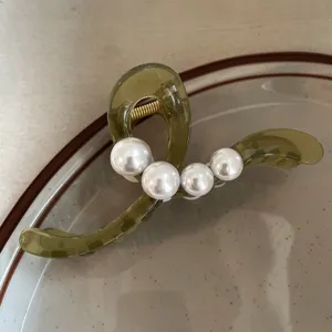 Detailaufnahme der eleganten grünen Perlen Haarkralle, stilvolles Damen Haaraccessoire.