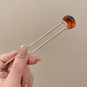 Detail shot of minimalist U-shaped hair stick with amber stone for vintage outfits.