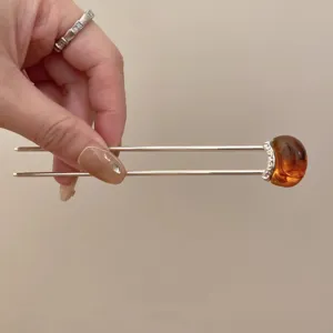 Detail view of a minimalist U-shaped hair stick with amber stone, ideal for vintage hair styling.