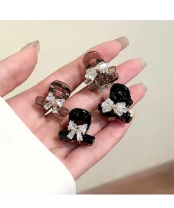 Close-up detail of small rhinestone bow hair claws, exquisite sparkling crystals, perfect for bangs.