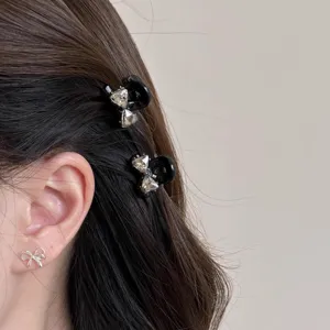 Nahaufnahme Detail von Strass Schleife Haarklammern getragen im dunklen Haar, eleganter Haarschmuck.