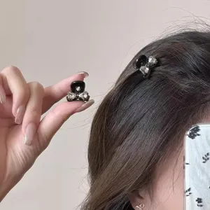 Kleiner schwarzer Strass Schleife Haarklammer Detailansicht mit funkelndem Kristall und Design.