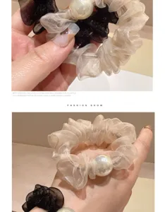 Detailopname van organza haarscrunchie met grote iriserende parel, elegante stijl.