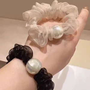 Chiffon haarrekkers met grote iriserende parels, elegante zwarte en beige elastische haarbanden.
