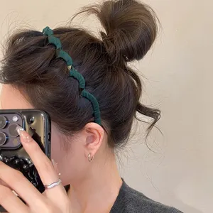 Close-up detail of dark green pleated braided hairband, stylish non-slip hair accessory.