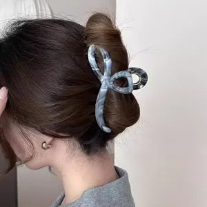 Detailaufnahme einer großen marmorierten Haarklammer mit elegantem grauen Muster und starkem Halt.