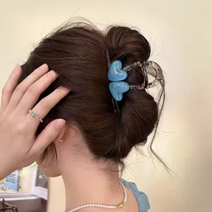 Nahaufnahme Detailansicht der eleganten blauen Herz Haarklammer im Dutt getragen.