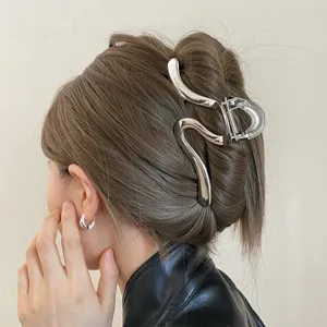 Detail shot of the minimalist irregular metallic hair claw clip showcasing fine texture and design.