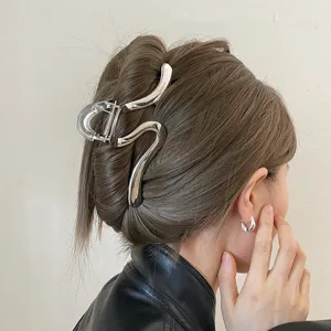 Minimalist silver metal hair claw clip for thick hair, elegant abstract line design detail.
