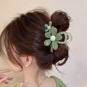 Green flower hair claw clip detail showcasing elegant resin design for stylish hairstyles.