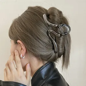 Minimalist irregular metallic hair claw clip for thick hair, elegant shark clip detail shot.