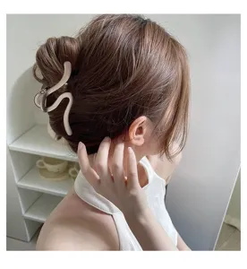 Elegant minimalist wavy metal hair claw clip detail view showing refined texture and secure hold.