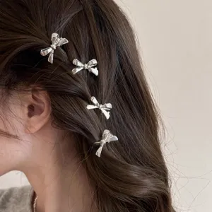 Vue détaillée des pinces à cheveux nœud en métal argenté, petits accessoires tendance.