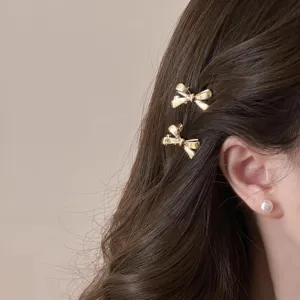 Gros plan de pinces à cheveux nœud en métal doré mignon portées sur des cheveux, accessoire.