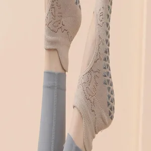 Close-up detail of beige yoga socks with anti-slip grip dots and knitted texture for pilates.