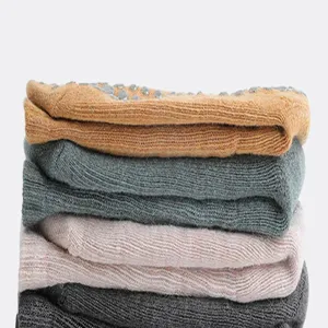 Detailansicht gestapelter dicker Anti-Rutsch Yoga-Socken in verschiedenen Pastellfarben.
