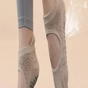 Detail shot of beige yoga socks featuring a hollow-out back design and non-slip grip soles.