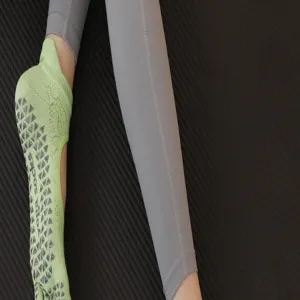 Close-up of women's five-toe non-slip yoga socks with grip texture and grey leggings.