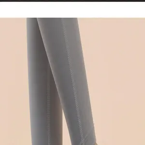 Detailed view of grey athletic leggings with fine seam stitching for yoga and fitness workout.
