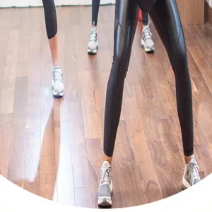 Fitness workout scene detail showing athletic leggings and sneakers on a wooden floor.