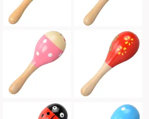 Wooden baby maracas detail showing colorful cartoon patterns and smooth natural handles.