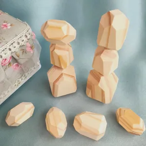 Gros plan de détails de jouets de pierres d'empilement en bois sur fond en tissu.