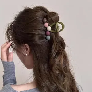 Detailed shot of a stylish medium hair claw clip with colorful beads for elegant women hairstyles.