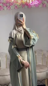 Detail shot of elegant long sleeve abaya robe featuring charming bow accents and belt.