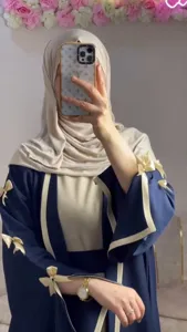 Elegant loose blue long abaya robe with chic cream bows and contrast trim for women.