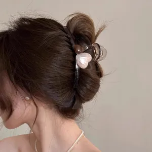 Detailansicht einer stilvollen Jelly Herz Haarklammer im Dutt für elegante Frisurentrends.