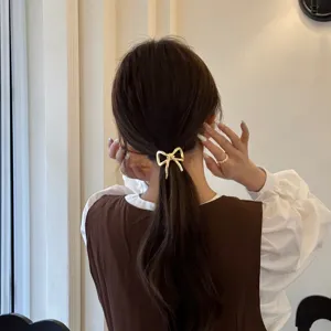 Elegante elastico per capelli con fiocco dorato da donna, accessorio chic per coda di cavallo.