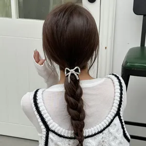 Dettaglio elastico per capelli con fiocco argento, elegante fermacoda, accessorio stiloso.