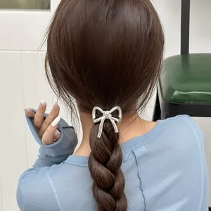 Vista dettagliata di un elegante elastico per capelli con fiocco argentato metallico.