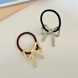 Dettaglio elastico per capelli con fiocco metallico stile francese, accessorio donna elegante.