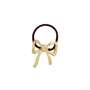 Elegante fermacapelli elastico con fiocco dorato metallico, perfetto per acconciatura.