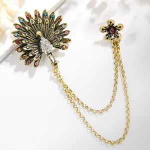 Vintage peacock brooch featuring colorful rhinestones, metal chain link, and exquisite detail.