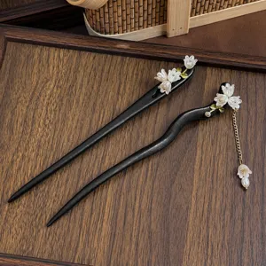Traditional Chinese style black wooden hair sticks detail view with floral decor and delicate tassel chain.