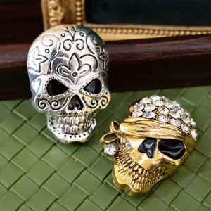 Detailed shot of two fashionable gothic skull brooches with rhinestones and vintage carving.