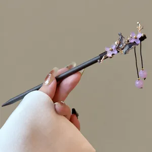 Detailed view of traditional Chinese wooden hair stick with floral design and elegant tassels.