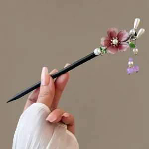 Nahaufnahme Detail der chinesischen Holzhaarspange mit rosa Blume und Perlenquaste.