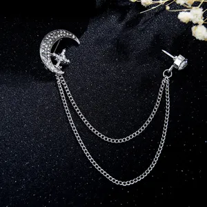 Detailed shot of sparkling rhinestone moon and star chain brooch with elegant metal tassel design.